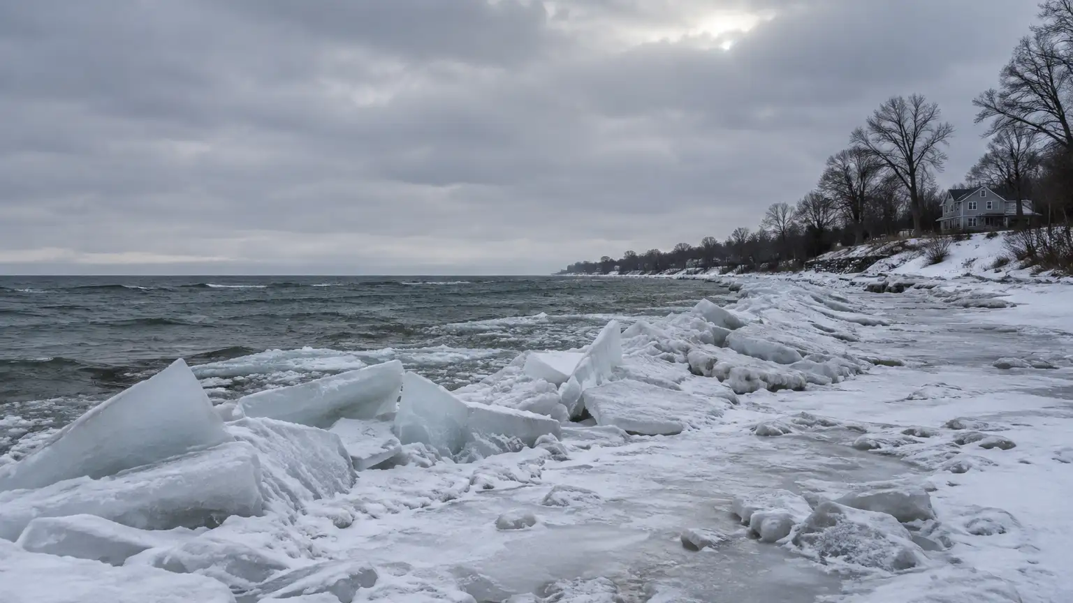 Broken lake ice piled along a frozen Great Lakes shoreline under a winter overcast